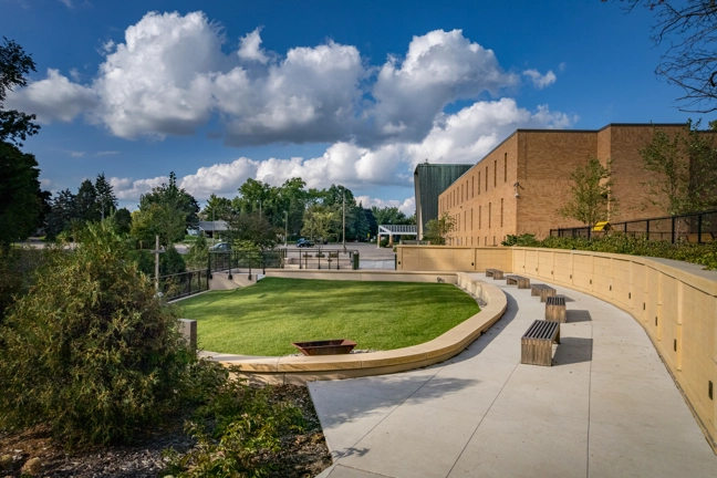 aerial view of bridge leading to open grass area with walkway around it
